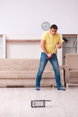 Genç adam ve fare kapanı evde.