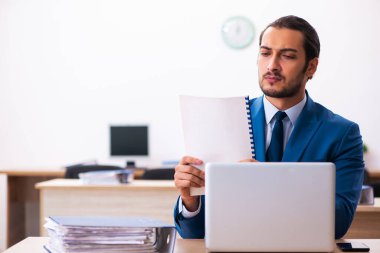 Ofiste oturan genç erkek satış analisti.