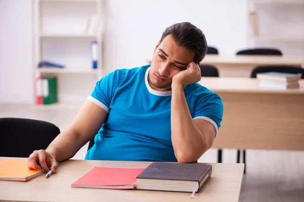Wyczerpany student przygotowujący się do egzaminów w klasie — Zdjęcie stockowe