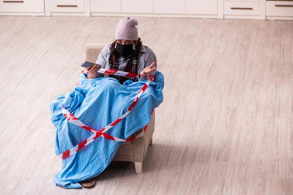 Jovem doente assistindo tv em casa em conceito pandêmico — Fotografia de Stock