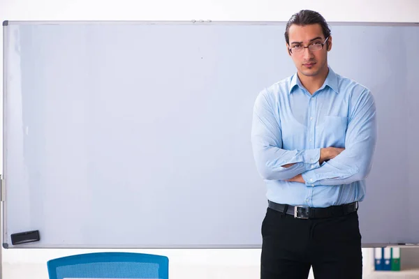 Genç yakışıklı öğretmen beyaz tahtanın önünde. — Stok fotoğraf