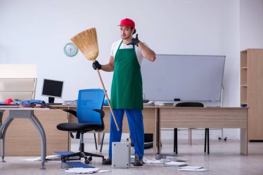 Genç müteahhit ofisi temizliyor.