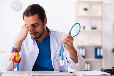 Klinikte çalışan genç bir erkek kardiyolog.