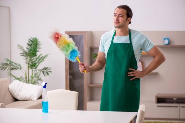 Genç erkek müteahhit evi temizliyor.