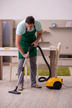 Genç erkek müteahhit evi temizliyor.