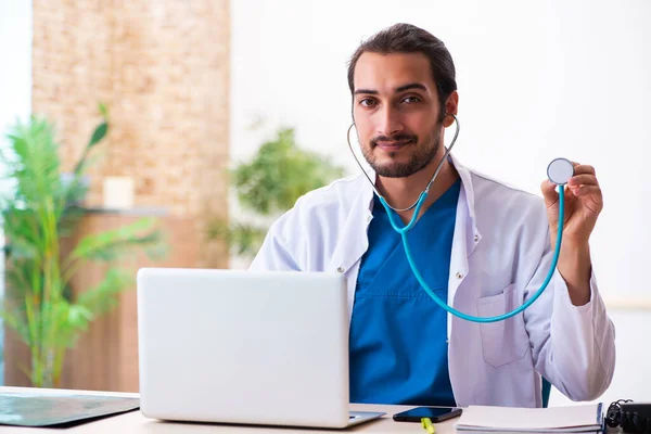 Jovem médico masculino segurando fonendoscópio — Fotografia de Stock