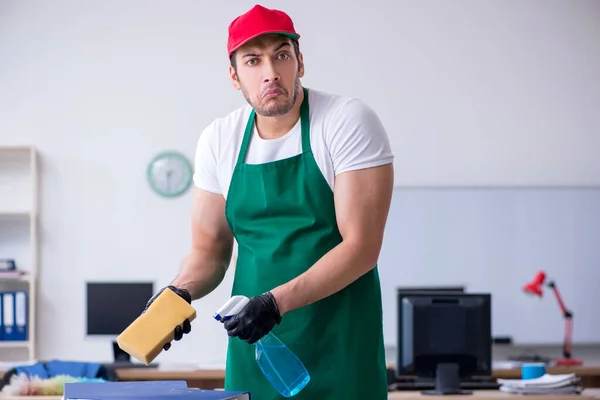 Young male contractor cleaning the office