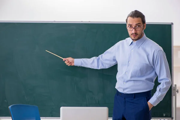 Jovem professor na sala de aula em frente ao quadro verde — Fotografia de Stock