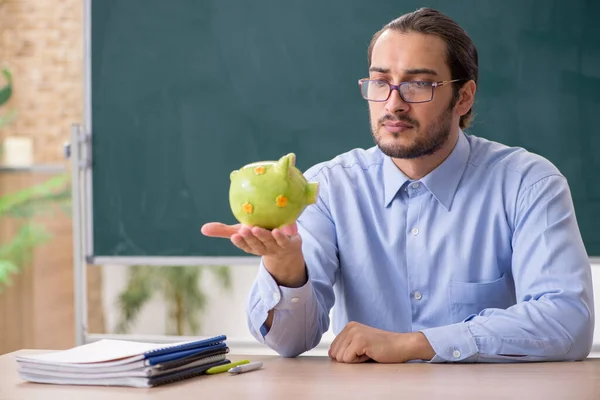 Jonge onderbetaalde mannelijke leraar in de klas — Stockfoto