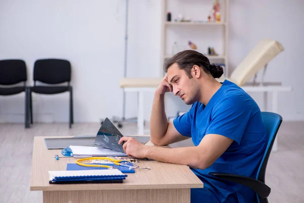 Genç erkek doktor radyoloji uzmanı gece vardiyasından sonra mutsuz oluyor. — Stok fotoğraf