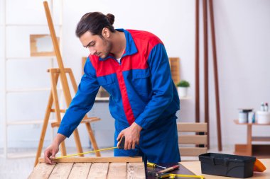 Genç erkek müteahhit atölyede çalışıyor.