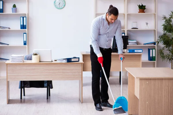 Unga manliga anställd rengöring kontor under pandemi — Stockfoto