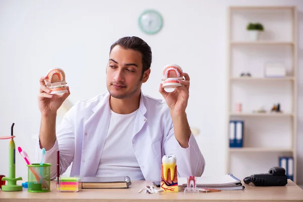 Jovem dentista do sexo masculino que trabalha na clínica — Fotografia de Stock