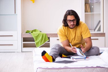 Evde sınava hazırlanan genç bir erkek öğrenci.