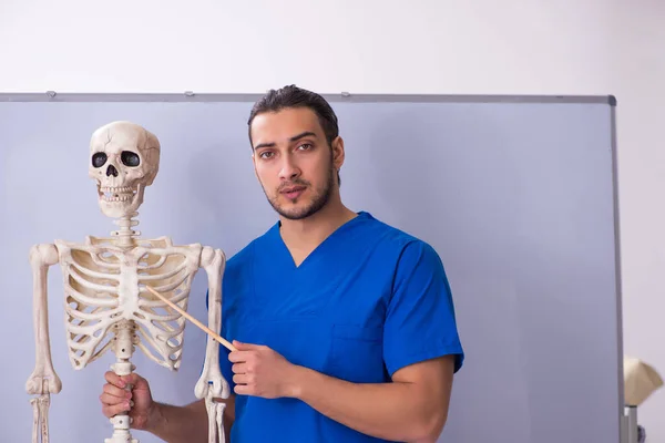 İskeleti beyaz tahtanın önünde olan genç bir erkek öğretim görevlisi. — Stok fotoğraf