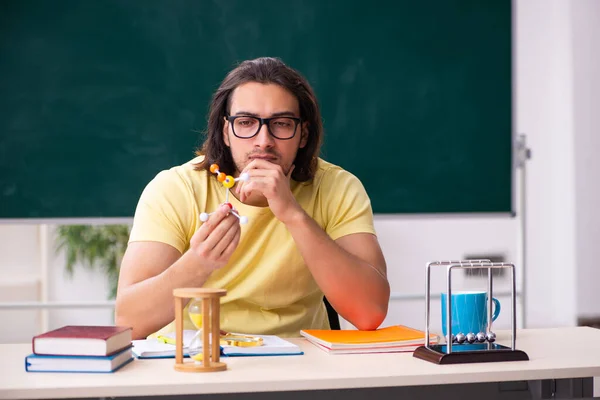 Ung manlig elev fysiker förbereder sig för tentor i klassrummet — Stockfoto