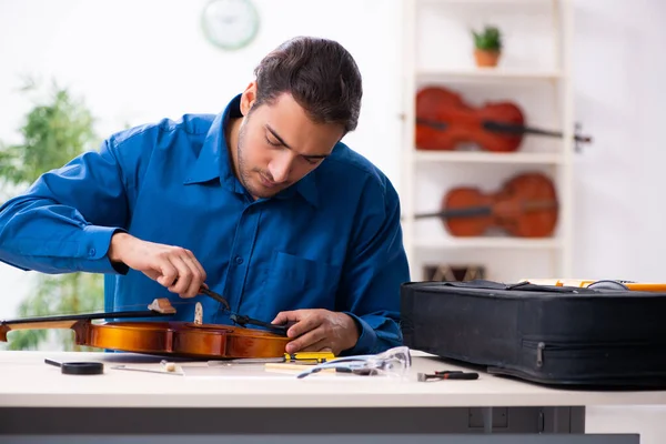 Junger Mann repariert Geige — Stockfoto