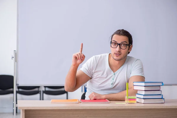 Mladý muž učitel student sedí ve třídě — Stock fotografie