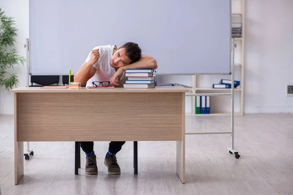 年轻的男教师坐在教室里 — 图库照片