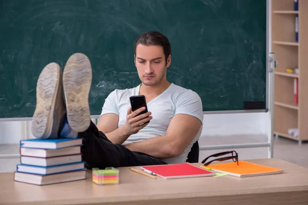 교실에 앉아 있는 젊은 남자 교사 — 스톡 사진