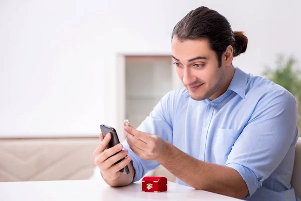 Joven hombre feliz con teléfono inteligente haciendo propuesta de matrimonio — Foto de Stock