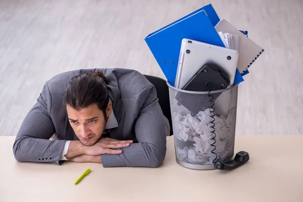 Fired young businessman with recycle bin in the office — Stock Photo, Image
