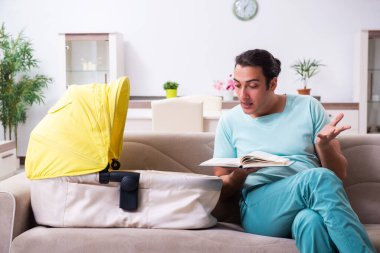 Genç erkek ebeveyn yeni doğan bebeğe evde bakıyor.