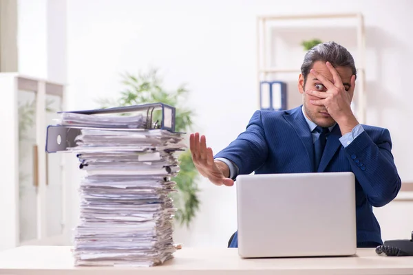 Young male employee unhappy with excessive work — Stock Photo, Image