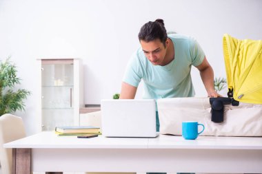 Genç erkek ebeveyn yeni doğan bebeğe evde bakıyor.