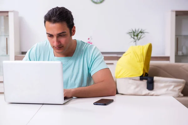 Jonge mannelijke ouder op zoek naar pasgeborene thuis — Stockfoto