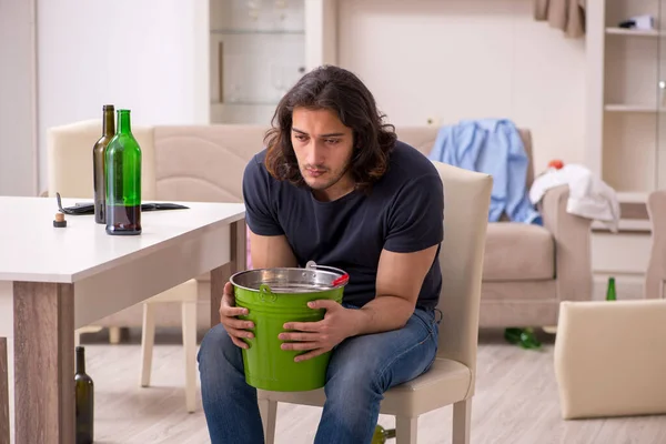 Jovem viciado em álcool homem que sofre de dor de estômago em casa — Fotografia de Stock