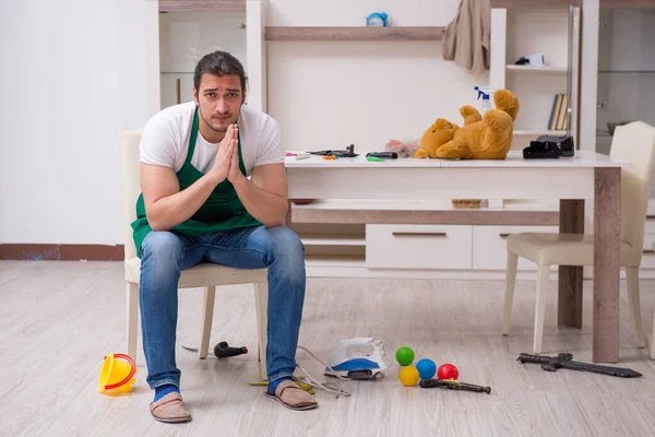 Young male contractor cleaning the flat after kids party — Stock Photo, Image