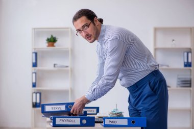 Ofiste vergi ödemelerini hesaplayan genç bir muhasebeci.