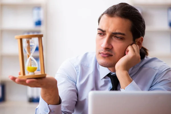 Jonge mannelijke werknemer in tijdmanagementconcept — Stockfoto