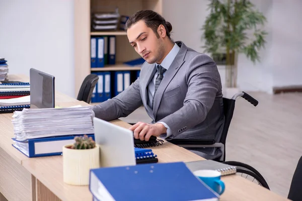 Giovane dipendente di sesso maschile in sedia a rotelle sul posto di lavoro — Foto Stock