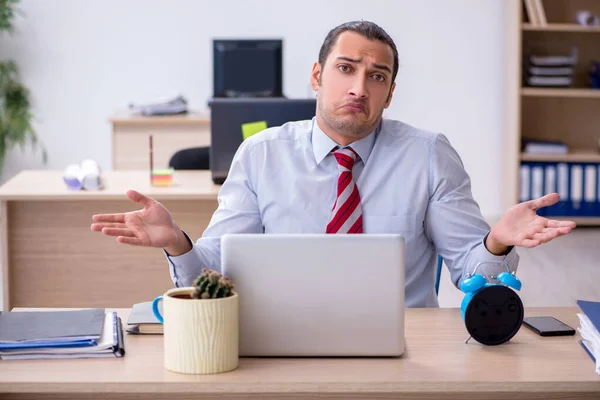 Joven empleado masculino en concepto de gestión del tiempo —  Fotos de Stock