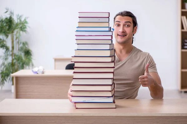 Joven estudiante masculino preparándose para los exámenes en la biblioteca — Foto de Stock