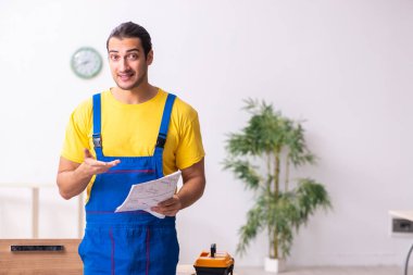 Genç erkek marangoz içeride çalışıyor.