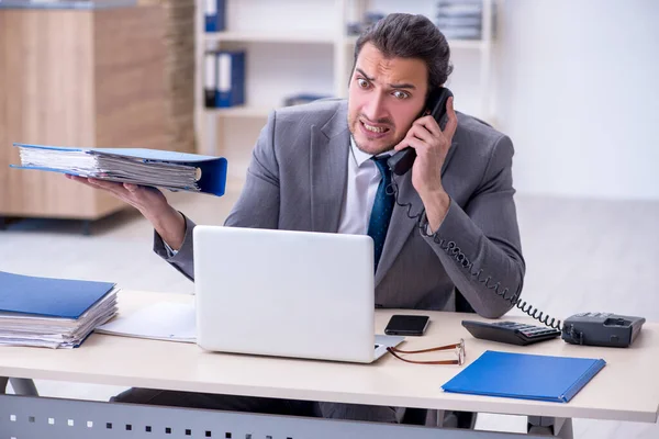 Junge männliche Angestellte unzufrieden mit exzessiver Arbeit im Büro — Stockfoto