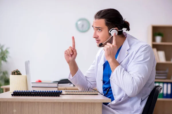 Jonge mannelijke arts in telegeneeskunde concept — Stockfoto