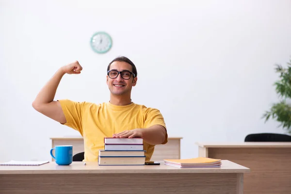 Ung manlig student förbereder sig för tentor i klassrummet — Stockfoto