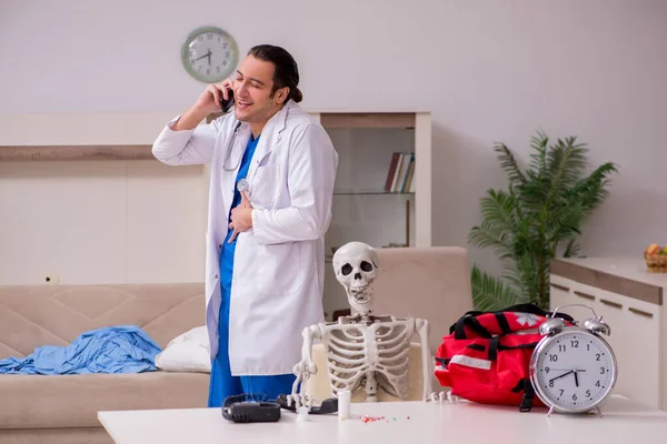 Jeune homme ambulancier visitant le squelette patient — Photo