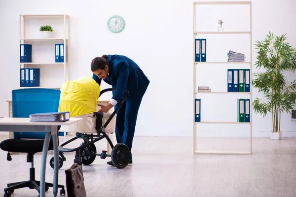 Joven empleado masculino que cuida niños en el lugar de trabajo — Foto de Stock