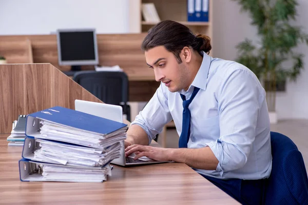 Joven empleado masculino infeliz con el trabajo excesivo — Foto de Stock