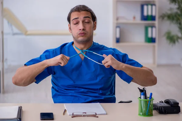 Joven doctor siendo extremadamente cansado en la clínica — Foto de Stock