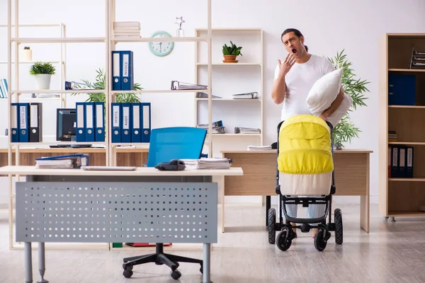 Junge männliche Angestellte kümmert sich um Neugeborenes am Arbeitsplatz — Stockfoto