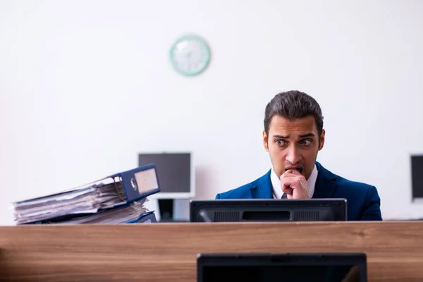 Karyawan laki-laki muda tidak bahagia dengan pekerjaan yang berlebihan di kantor — Stok Foto