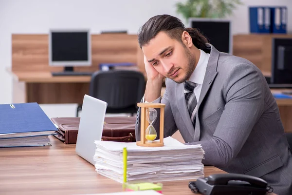 Jonge mannelijke werknemer die op kantoor werkt — Stockfoto