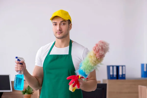 Junge männliche Auftragnehmer putzen das Büro — Stockfoto