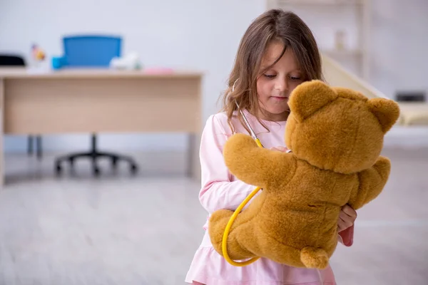 小さな女の子保持クマおもちゃ待っていますのために医者でザクリニック — ストック写真